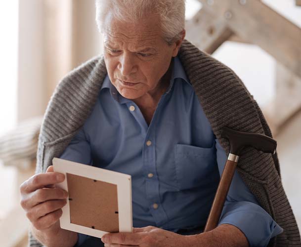 Older man holding a picture frame