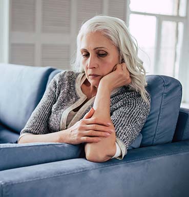 grieving woman on sofa after loss of loved one