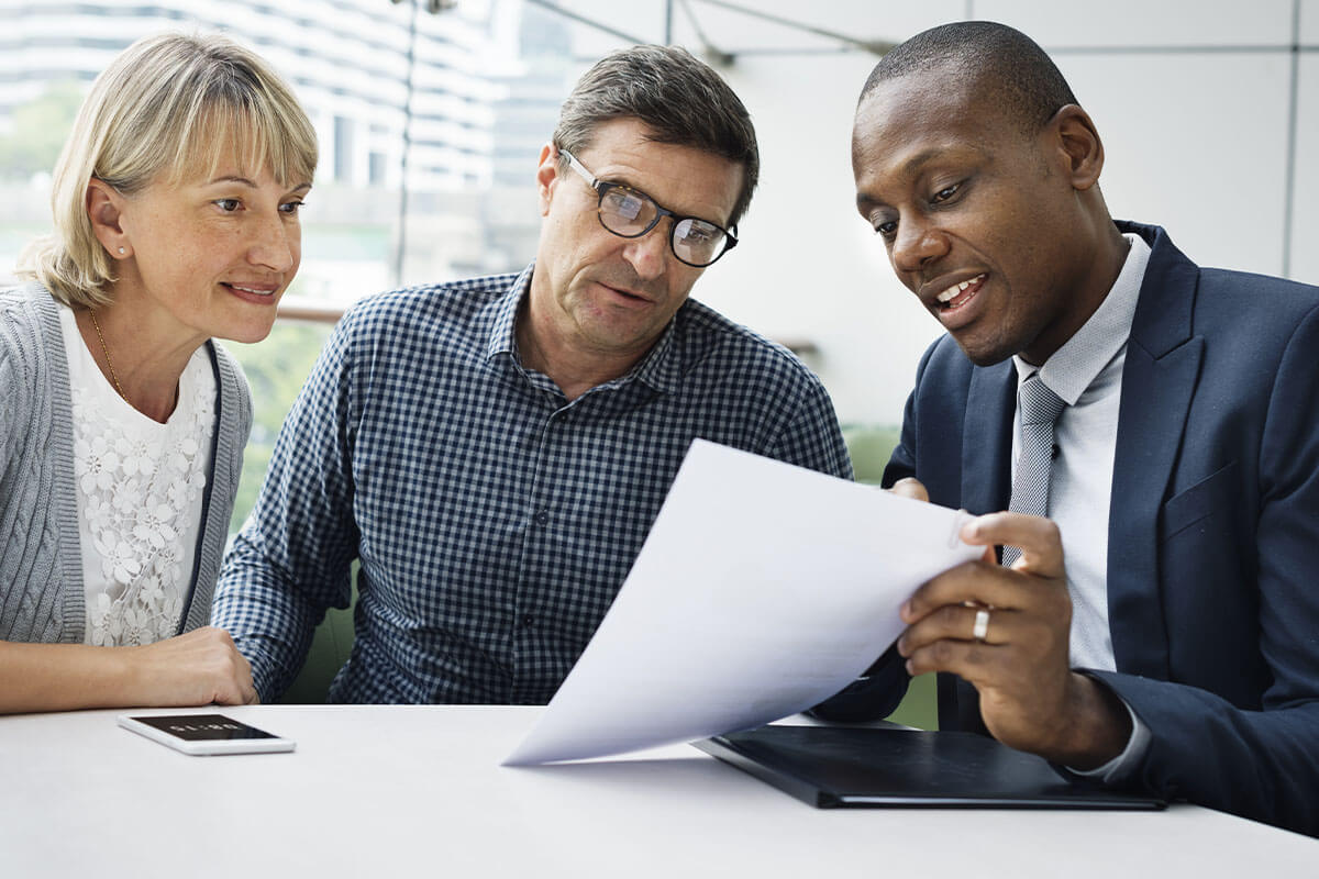 couple reading document at table with financial advisor